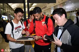 上海上港抵达广州大受欢迎 球迷热情接机求签名合影图片