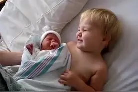 小男孩抱着刚出生的妹妹特别开心，但妹妹被抱走时却伤心的大哭图片